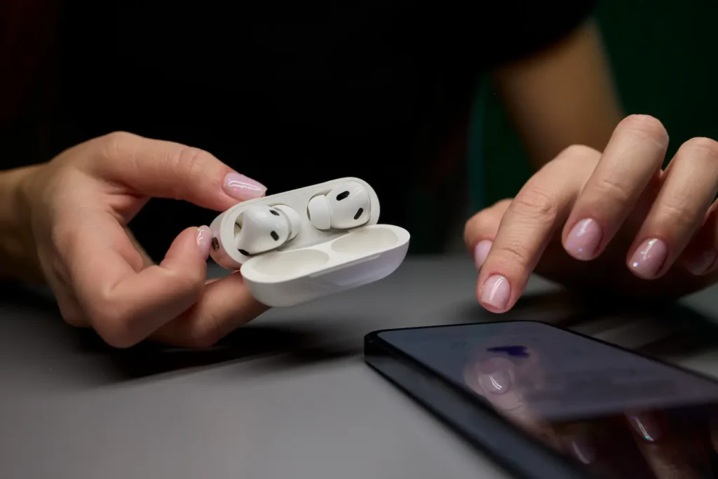 Os melhores fones bluetooth custo-benefício de 2026: como escolher sem pagar caro pela marca 2 Pessoa manuseando fones Bluetooth sem fio conectados a um smartphone, representando a análise de critérios técnicos para escolha em 2026.