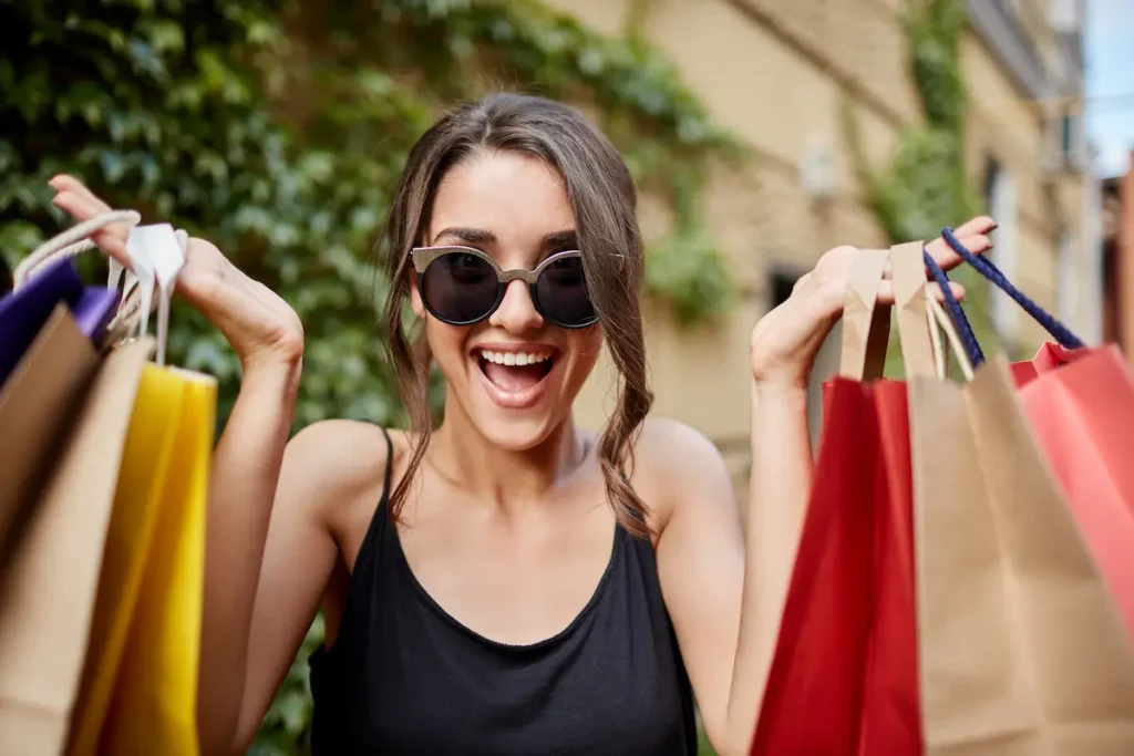 Dia do Cliente 2026: comércio faz promoções em 15 de setembro; confira os direitos na compra 2 Consumidora sorrindo com sacolas de compras representando ofertas do Dia do Cliente e direitos garantidos nas compras..
