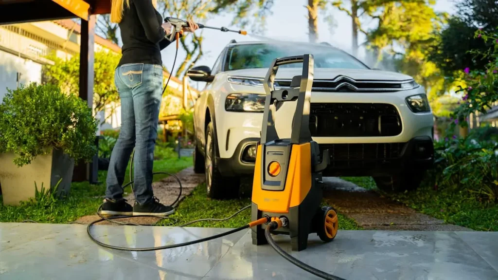 Lavadora WAP Combate Turbo 2600: veja em qual loja a lavadora de alta pressão está mais barata 2 Pessoa utilizando lavadora de alta pressão WAP Combate Turbo 2600 para limpar veículo.